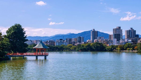 Hexagonal red pavilion in Ohori Lake Park overlooking Fukuoka City