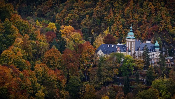 A panoramic view of the Lillafüred Palace Hotel, surrounded by vibrant autumn foliage in the Bükk Mountains