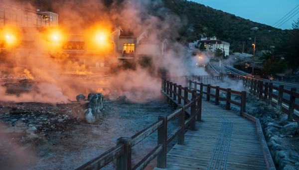 Mount Unzen Jigoku with sulphur gas hot springs and ryokan at night with lights across Shimabara City
