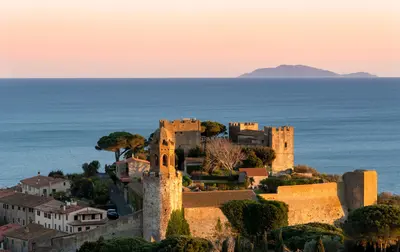 Castiglione della Pescaia, con vistas panorámicas a la puesta de sol del Castillo, en el fondo de la isla de Giglio.