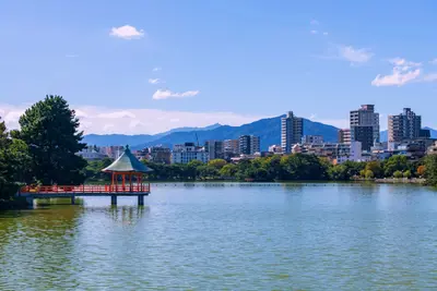 Hexagonal red pavilion in Ohori Lake Park overlooking Fukuoka City