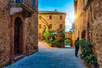 Calle acogedora decorada con flores de colores, Pienza